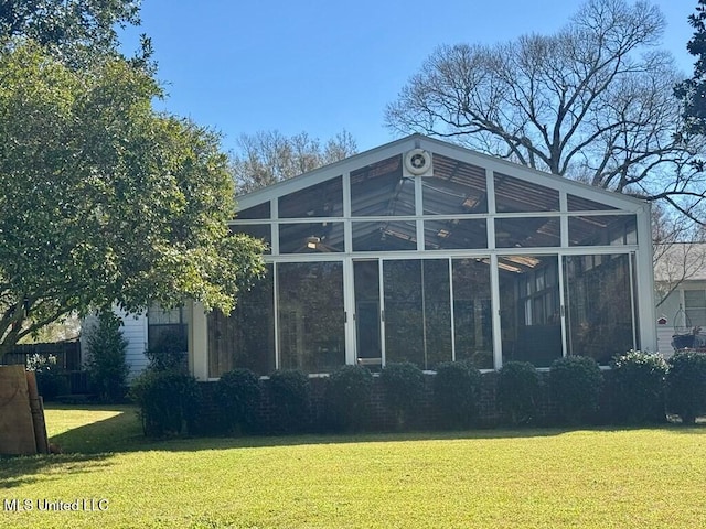 view of side of property with a sunroom and a yard