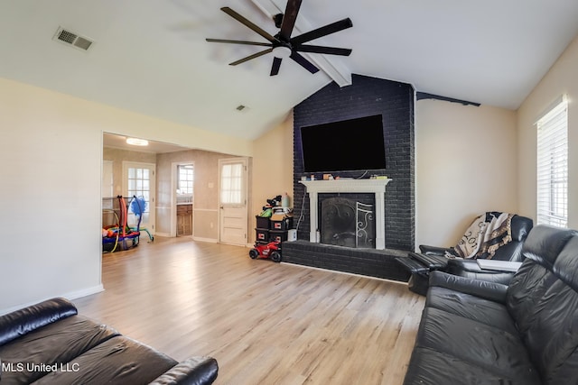 living room featuring visible vents, a brick fireplace, ceiling fan, and wood finished floors