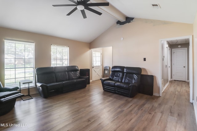 living area featuring ceiling fan, visible vents, wood finished floors, baseboards, and vaulted ceiling with beams