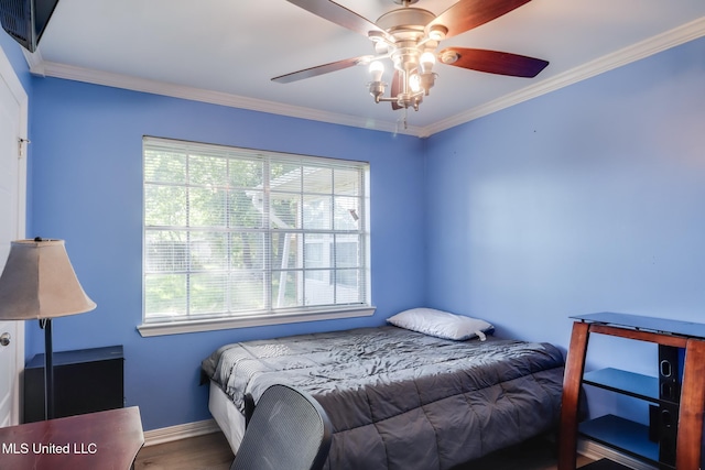 bedroom with crown molding, baseboards, and multiple windows