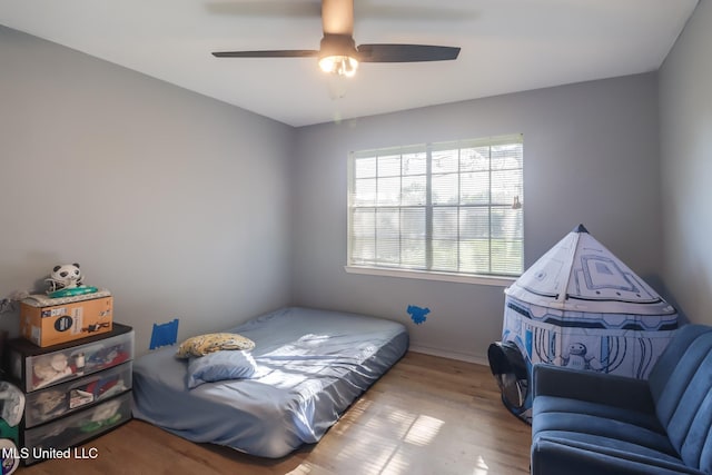 bedroom with baseboards, ceiling fan, and wood finished floors