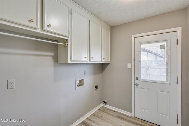 laundry room with baseboards, cabinet space, washer hookup, a textured ceiling, and light wood-type flooring