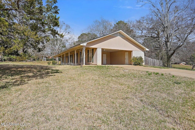 view of front facade featuring driveway, an attached carport, fence, a front yard, and brick siding