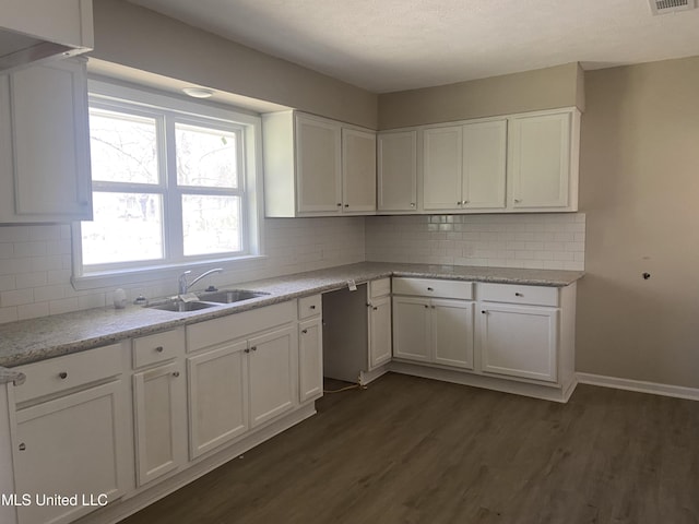 kitchen with white cabinets, dark wood-style flooring, backsplash, and a sink