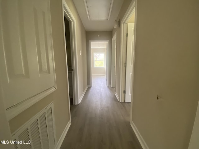 corridor with visible vents, baseboards, and attic access