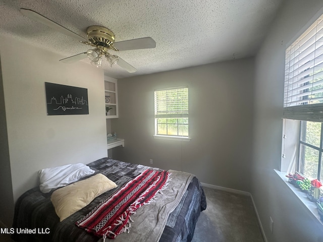 carpeted bedroom featuring ceiling fan and a textured ceiling