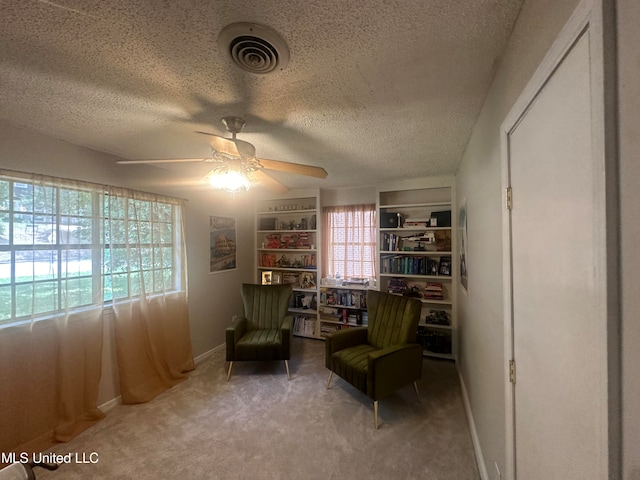 sitting room featuring carpet flooring, a textured ceiling, a wealth of natural light, and ceiling fan