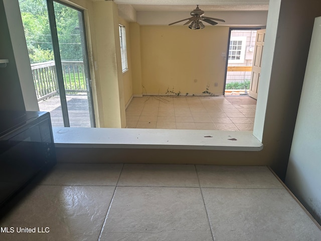 hallway with light tile patterned flooring and a textured ceiling