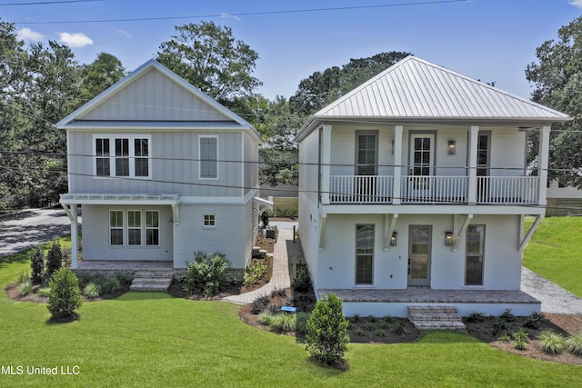 view of front of house featuring a front yard and a balcony