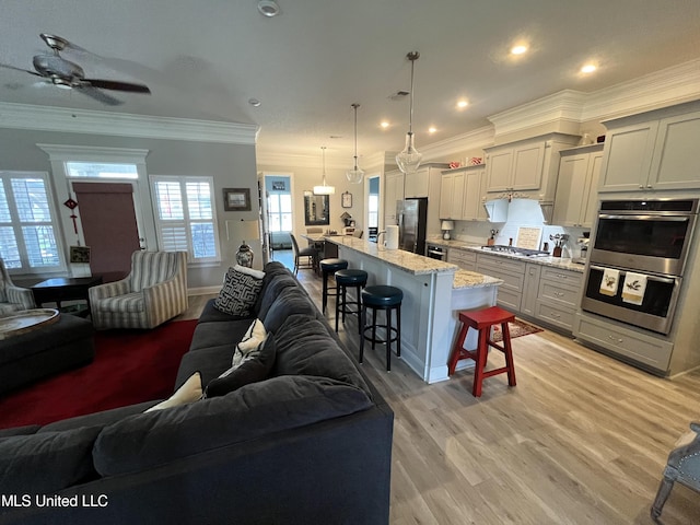 living room featuring recessed lighting, ceiling fan, light wood-type flooring, visible vents, and ornamental molding