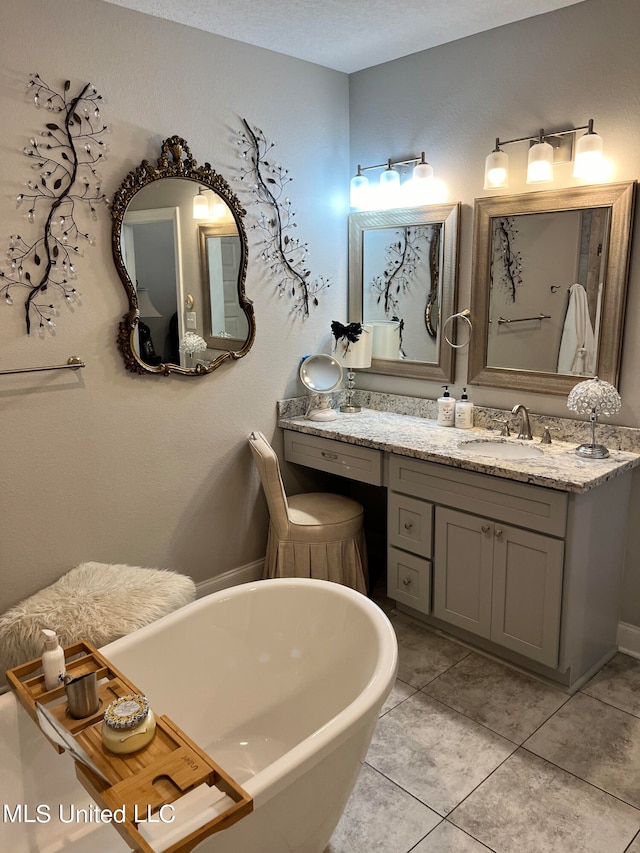 bathroom featuring vanity, a textured ceiling, tile patterned floors, and a bath