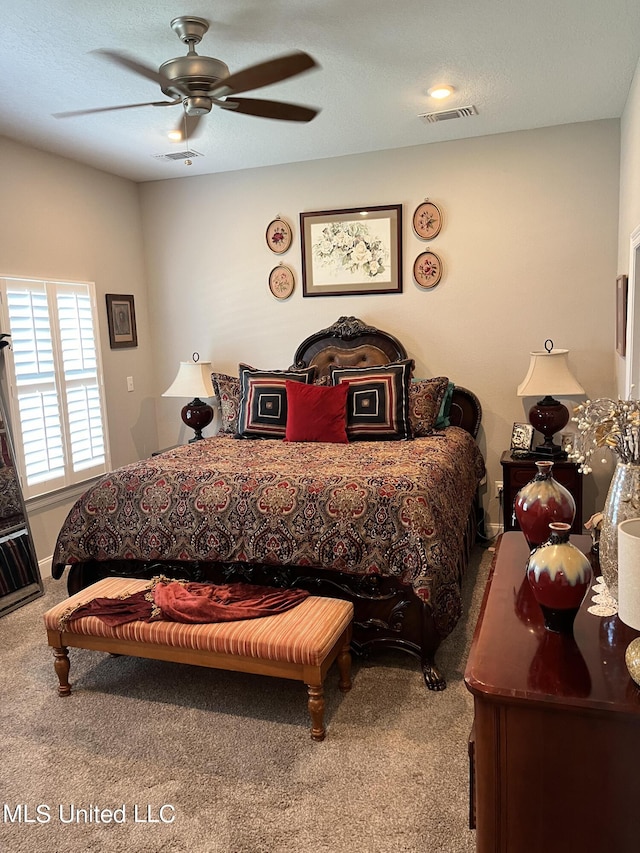 carpeted bedroom with visible vents and a ceiling fan