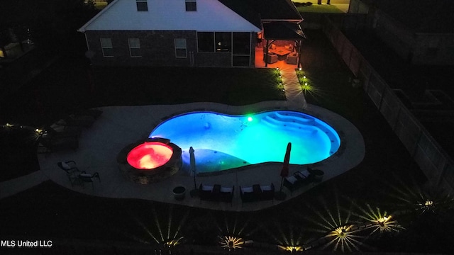 pool at twilight with a patio area