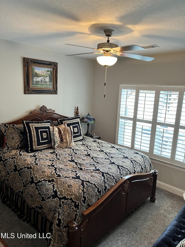 carpeted bedroom featuring a ceiling fan, visible vents, a textured ceiling, and baseboards