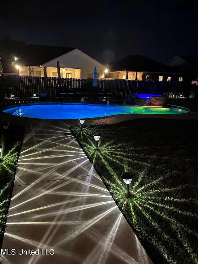 view of pool at twilight