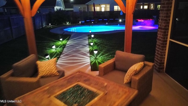 pool at night featuring a fenced in pool and a fenced backyard
