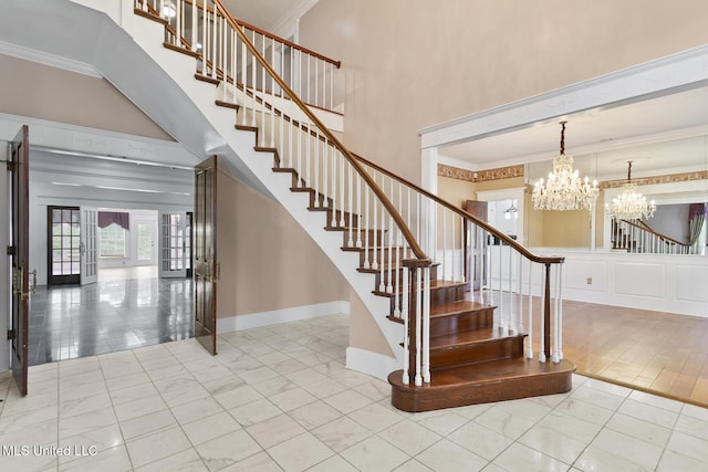 stairs featuring tile patterned floors, a chandelier, crown molding, and french doors