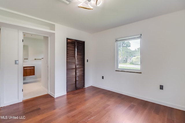 unfurnished bedroom featuring a closet and dark hardwood / wood-style flooring