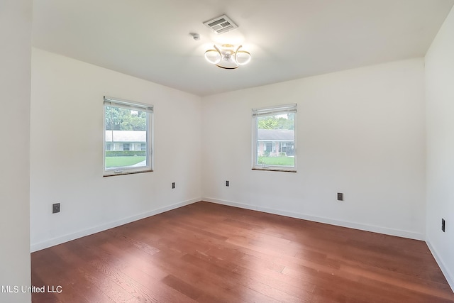 unfurnished room featuring dark wood-type flooring and a wealth of natural light