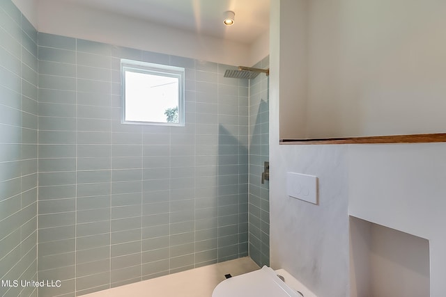 bathroom with toilet and a tile shower