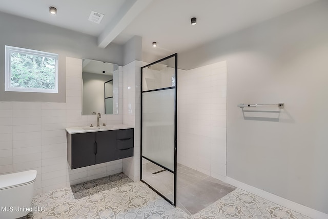 bathroom featuring tiled shower, tile patterned floors, toilet, vanity, and tile walls