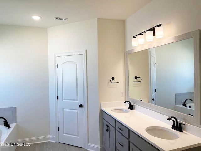 12111 Walker Rd, Ocean Springs, MS 39564 - bathroom featuring double vanity, a garden tub, visible vents, and a sink