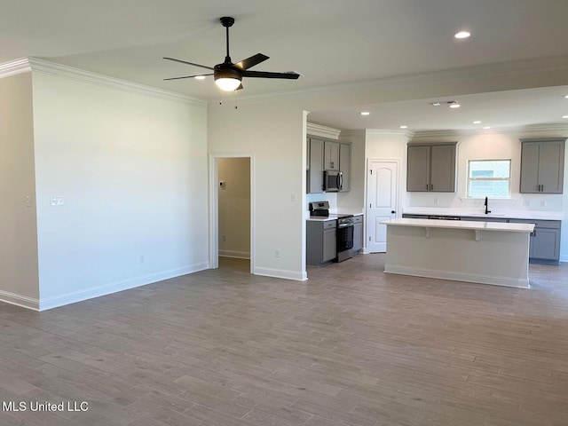 12111 Walker Rd, Ocean Springs, MS 39564 - kitchen featuring a sink, open floor plan, gray cabinetry, appliances with stainless steel finishes, and ornamental molding