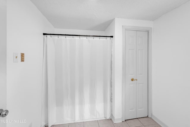 5423 Kaiki Dr, Diamondhead, MS 39525 - full bathroom featuring a closet, tile patterned floors, a textured ceiling, and curtained shower