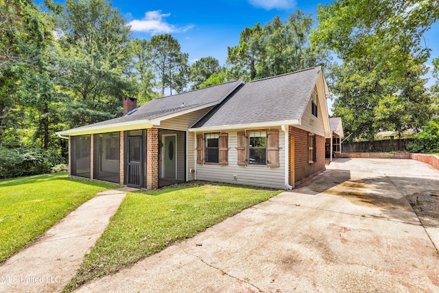5423 Kaiki Dr, Diamondhead, MS 39525 - view of front of home featuring brick siding, driveway, a sunroom, a shingled roof, and a chimney