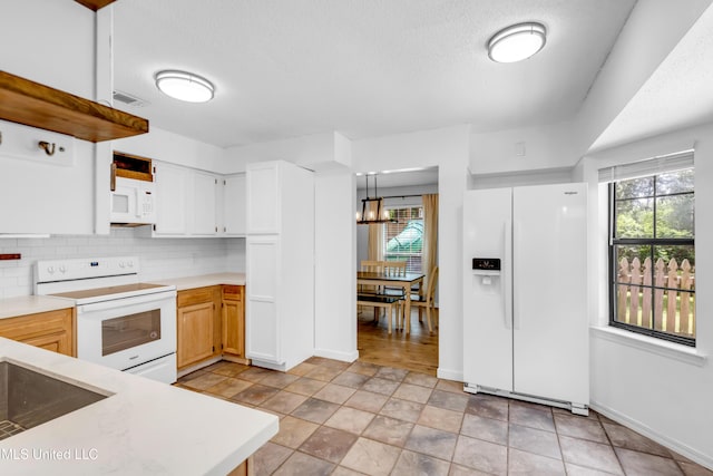 5423 Kaiki Dr, Diamondhead, MS 39525 - kitchen with white appliances, light countertops, plenty of natural light, tasteful backsplash, and a textured ceiling