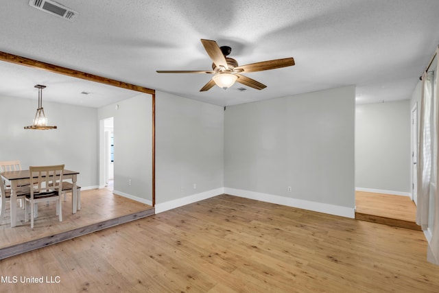 5423 Kaiki Dr, Diamondhead, MS 39525 - spare room with a ceiling fan, light wood-type flooring, a chandelier, and a textured ceiling
