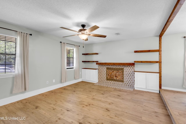 5423 Kaiki Dr, Diamondhead, MS 39525 - unfurnished living room featuring light wood-style flooring, ceiling fan, and a textured ceiling