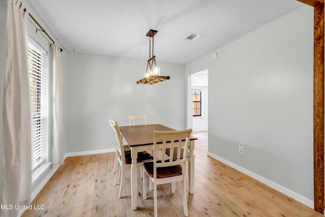 5423 Kaiki Dr, Diamondhead, MS 39525 - dining area featuring light wood-style floors, plenty of natural light, and a textured ceiling