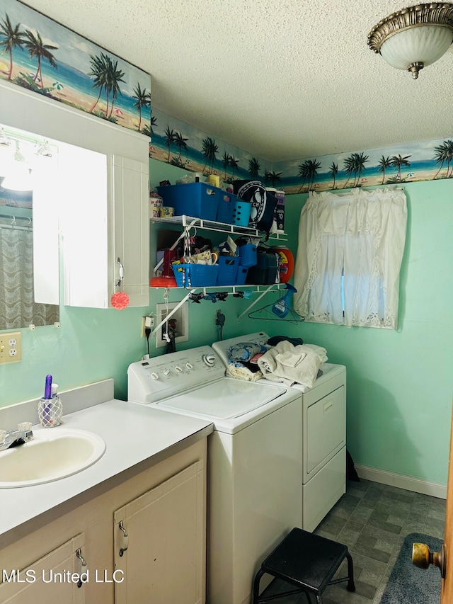 laundry room featuring washer and dryer, sink, and a textured ceiling