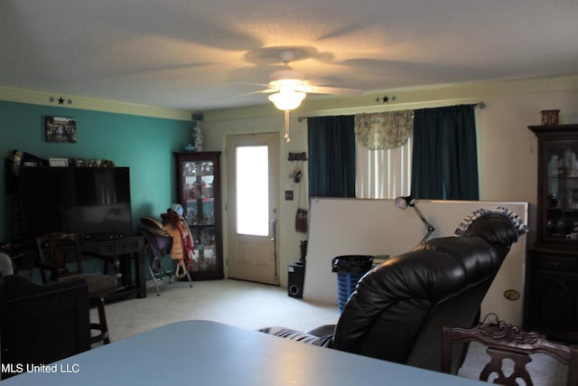 carpeted living room featuring ceiling fan and a textured ceiling