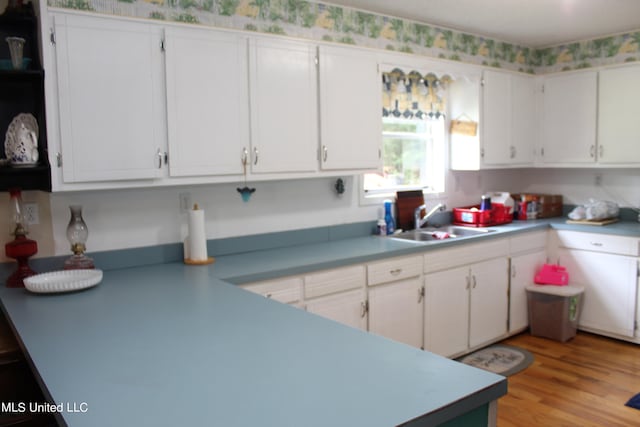 kitchen featuring light hardwood / wood-style floors, white cabinets, and sink