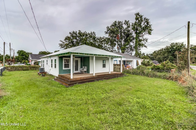 view of front of home with a front yard, a porch, and central air condition unit