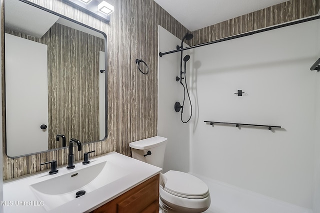 bathroom featuring a shower, toilet, and vanity