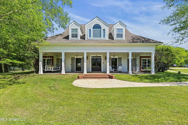 view of front of home with a front yard, ceiling fan, and roof with shingles