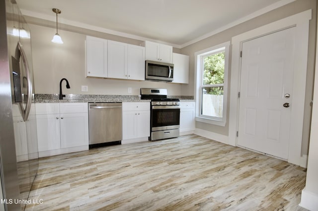 2200 19th Ave, Gulfport, MS 39501 - kitchen with appliances with stainless steel finishes, light wood-style floors, light stone countertops, white cabinetry, and pendant lighting