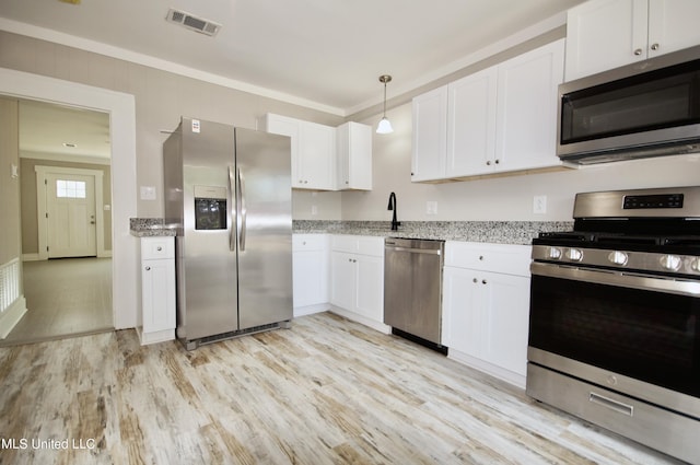 2200 19th Ave, Gulfport, MS 39501 - kitchen with appliances with stainless steel finishes, light wood-type flooring, white cabinetry, light stone countertops, and ornamental molding