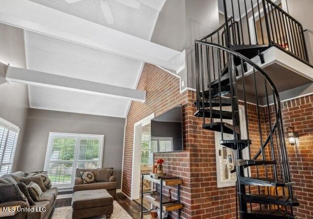 4424 Rebekah Dr, Olive Branch, MS 38654 - living area featuring stairs, wood finished floors, high vaulted ceiling, brick wall, and a ceiling fan