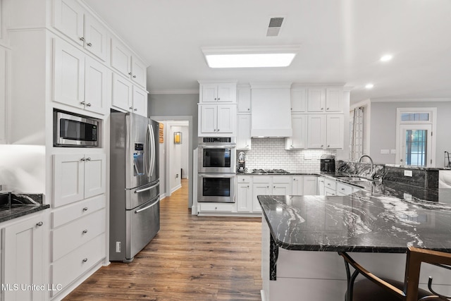 4424 Rebekah Dr, Olive Branch, MS 38654 - kitchen with stainless steel appliances, crown molding, a breakfast bar, wood finished floors, and recessed lighting