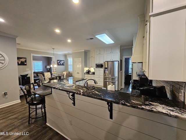 4424 Rebekah Dr, Olive Branch, MS 38654 - kitchen featuring stainless steel appliances, crown molding, dark wood finished floors, a breakfast bar area, and white cabinetry