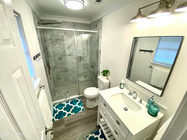 bathroom with toilet, vanity, a shower with shower door, and hardwood / wood-style flooring