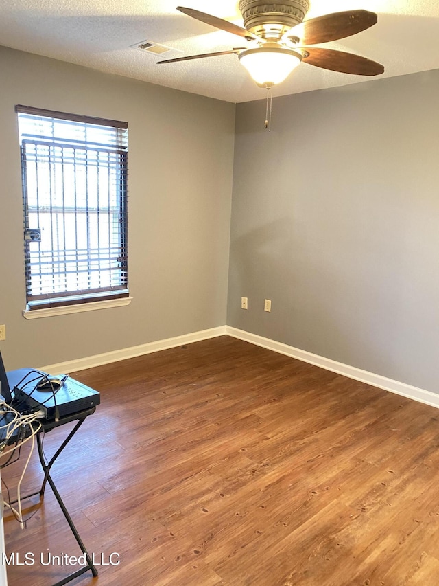 empty room featuring hardwood / wood-style floors, a textured ceiling, and ceiling fan