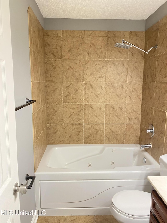 full bathroom with tile patterned floors, toilet, tiled shower / bath, a textured ceiling, and vanity