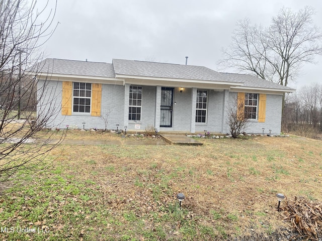 single story home with covered porch and a front yard