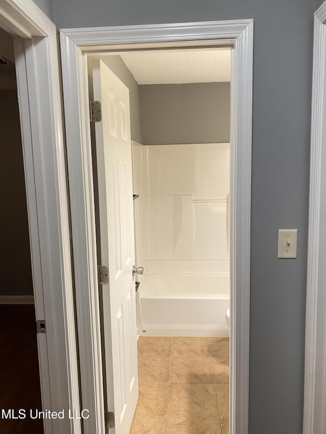 bathroom featuring tile patterned flooring, a textured ceiling, and toilet