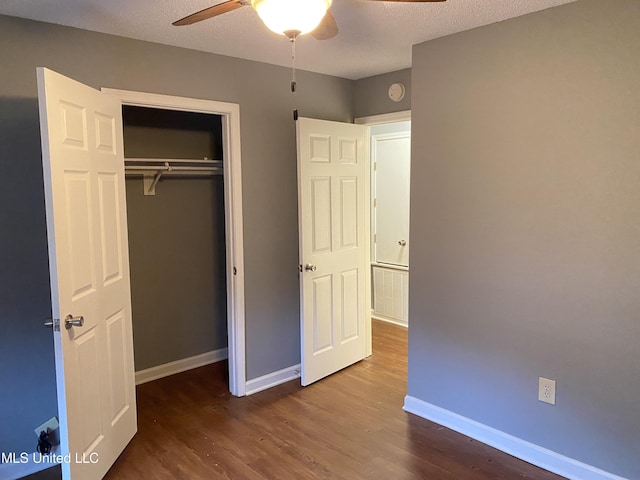 unfurnished bedroom featuring hardwood / wood-style floors, a textured ceiling, ceiling fan, and a closet